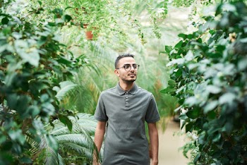 Man Wearing Polo Shirt Standing Near Green Leafed Plants