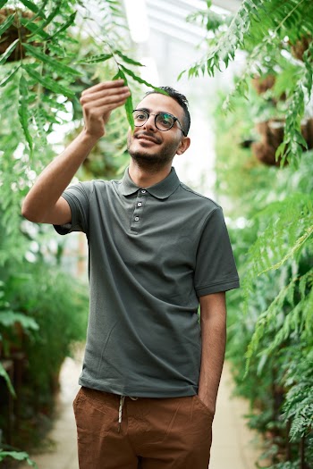 Man Wearing Polo Shirt While Touching a Plant