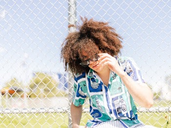 Man Wearing Printed Shirt Holding A Black Wayfarer Sunglasses