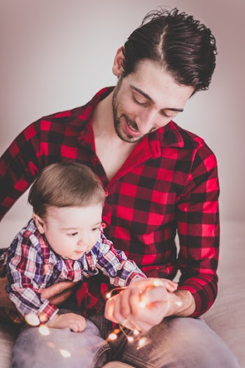 Man Wearing Red and Black Gingham Sports Shirt With Baby Beside Him