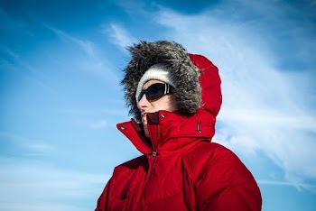 Man Wearing Red and Gray Fur Jacket and Sunglasses
