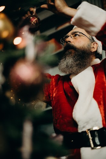 Man Wearing Red and White Santa Costume Holding Red Christmas Ball