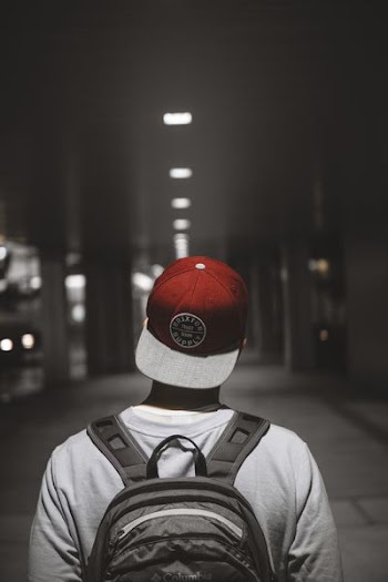 man wearing red cap facing the hallway