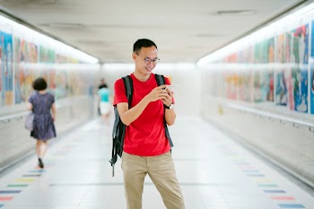 Man Wearing Red Crew-neck T-shirt and Brown Pants Photo