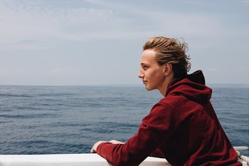 Man Wearing Red Hoodie Leaning On Railing