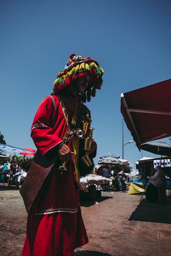 Man Wearing Red Robe With Headdress Near Awning