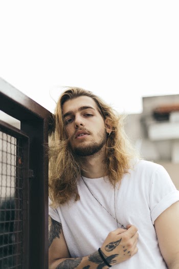 Man Wearing Shirt and Leaning on the Gate