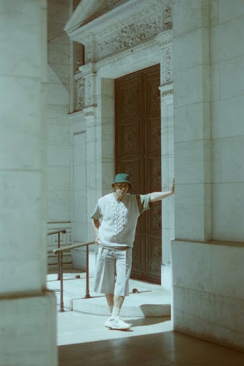Man Wearing Shorts Standing Beside a Doorway · Free Stock Photo