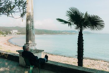 man wearing sitting on chair while watching sea