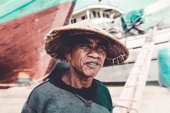 man wearing straw hat near ships during day