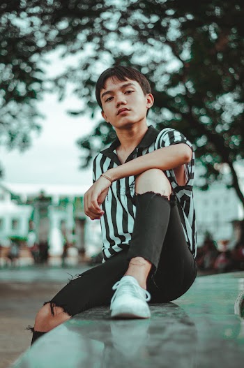 Man Wearing Striped Shirt and Ripped Jeans