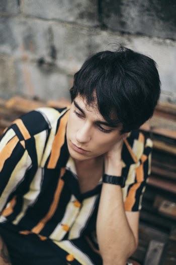Man Wearing Striped Shirt Sitting on Chair Outdoor