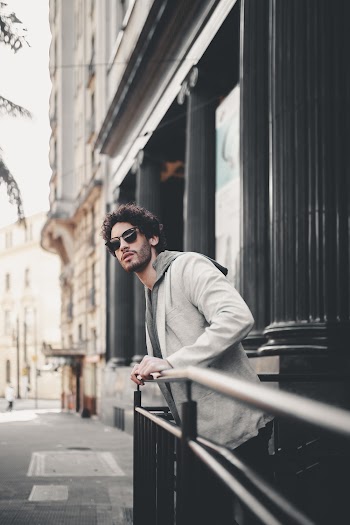 Man Wearing Suit Jacket Holding on Rail