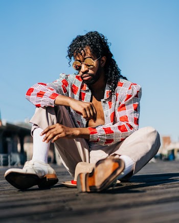 Man Wearing Sunglasses Sitting on Pavement