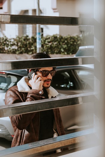 Man Wearing Sunglasses While Using His Cellphone