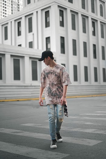 Man Wearing Tie-dye Shirt and Denim Jeans Walking on the Street