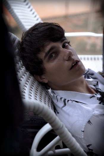 Man Wearing White and Black Casual Shirt Sitting on Chair