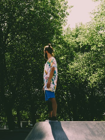 Man Wearing White and Multicolored Floral Standing Near Trees