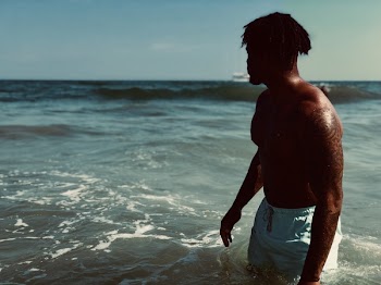 Man Wearing White Boardshorts at Sea