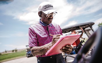 Man Wearing White Cap and Holding Printer Paper and Pen