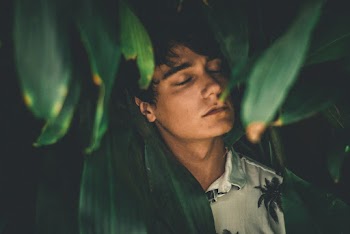 Man Wearing White Collared Shirt Leaning On Leaves While Closing His Eyes