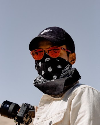 Man Wearing White Collared Top With Black Cap While Holding Black Dlsr Camera