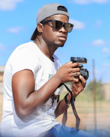 Man Wearing White Crew-neck Shirt Holding Black Camera
