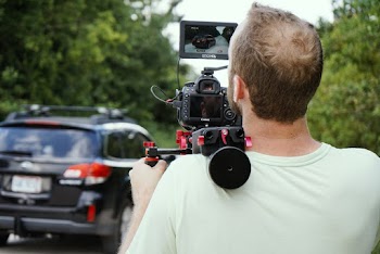 Man Wearing White Crew-neck Shirt Holding Black Video Camera