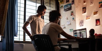 Man Wearing White Crew-neck Shirt Sitting on Black Chair While Using Laptop