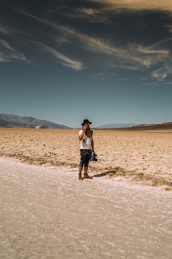Man Wearing White Crew-neck T-shirt Standing Near Road