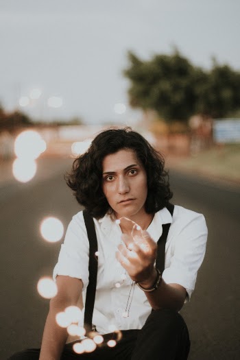 Man Wearing White Dress Shirt and Black Pants With Suspender Belt Holding Light With Bokeh Effect