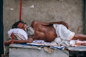 Man Wearing White Shorts Lying On Wooden Bed