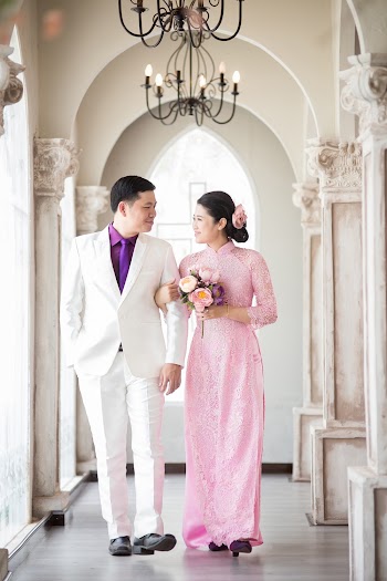 Man Wearing White Suit Jacket and Woman Wearing Pink Long-sleeved Dress Walking Corridor