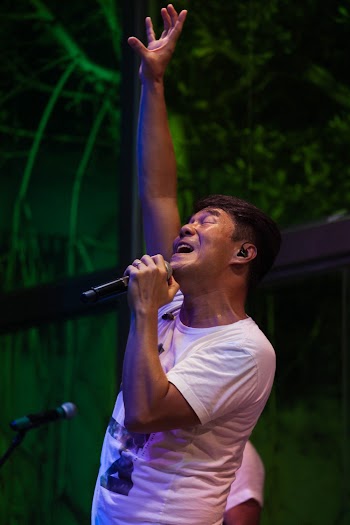 Man Wearing White T-shirt Singing at the Stage