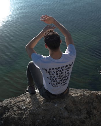 Man Wearing White T-shirt Sitting on Rock