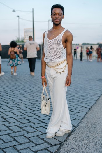 Man Wearing White Tank Top and Pants Standing on Street