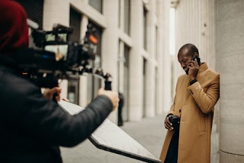 Man Wearing Yellow Coat Using Smartphone