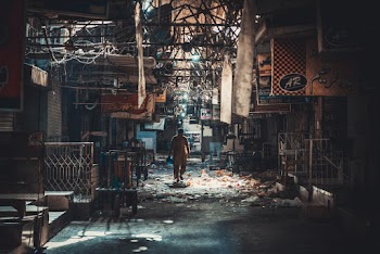 Man Wearing Yellow Overall Pants Between Buildings