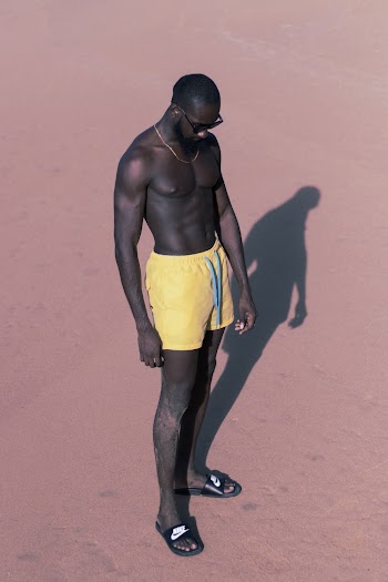 Man Wearing Yellow Shorts While Standing on Brown Sand