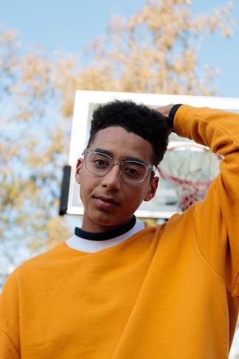 man wearing yellow sweater near basketball hoop