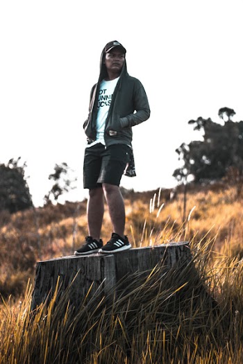 Man Wearing Zip-up Hoodie Standing On Tree Stump