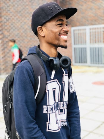 Man Wears Black Cap, Blue Hoodie and Backpack at the School