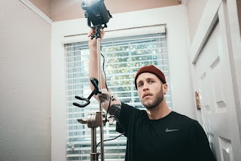 Man Wears Black Nike Crew-neck Shirt Holds Light With Stand