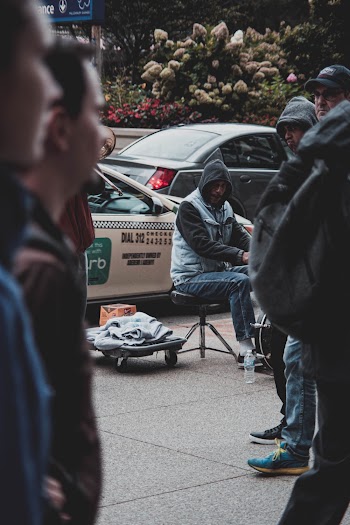 Man Wears White and Black Hoodie Jacket Sitting on Stool