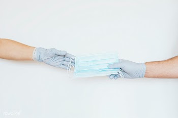 Man with a glove sharing a face mask to a friend on a gray background | Free  photo - 2350868