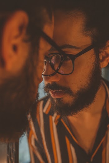 Man With Eyeglasses Looking to Mirror