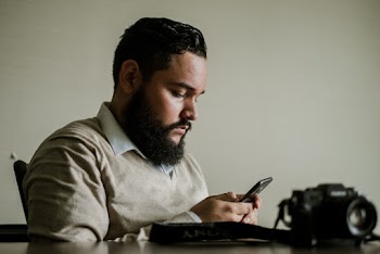 Man With Facial Hair Holds Smartphone
