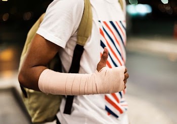 man with hand bandage wearing backpack standing