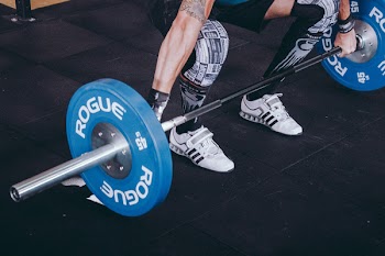 Man With Lift Stance Holds Blue Rogue Adjustable Barbell