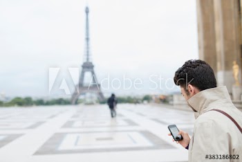 Man with smart phone, Eiffel Tower, Paris, France